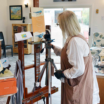 An Image of artist Rosie Ratigan working on a study of buntings in her Lander studio.